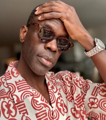 Series star poses in bold Lukas print shirt paired with Ferris sunglasses by Richard James