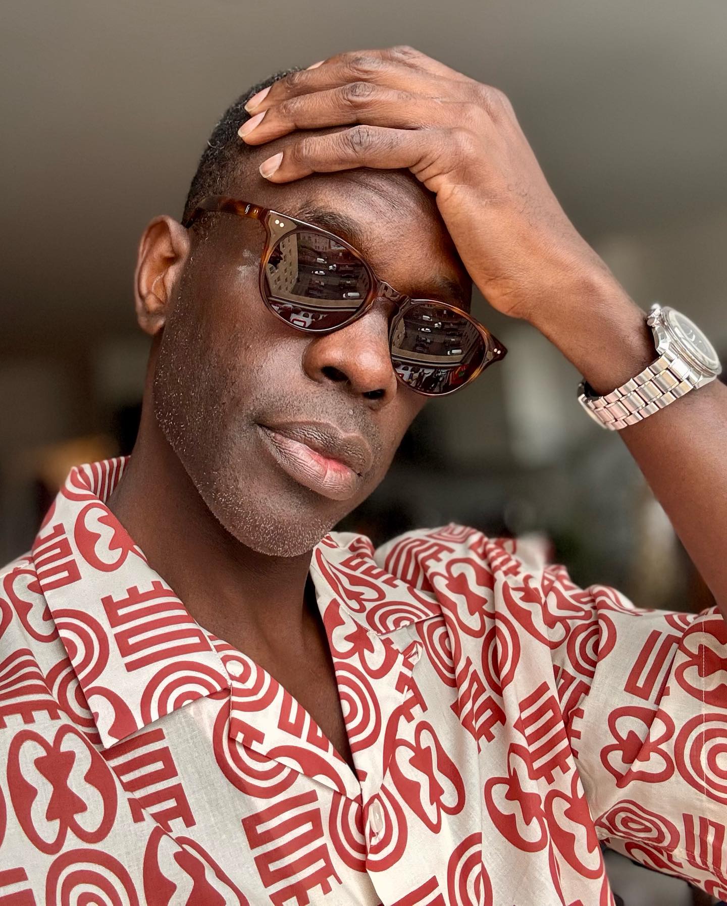 Ato Essandoh Wears Armando Cabral in New Netflix Shoot Series star poses in bold Lukas print shirt paired with Ferris sunglasses by Richard James
