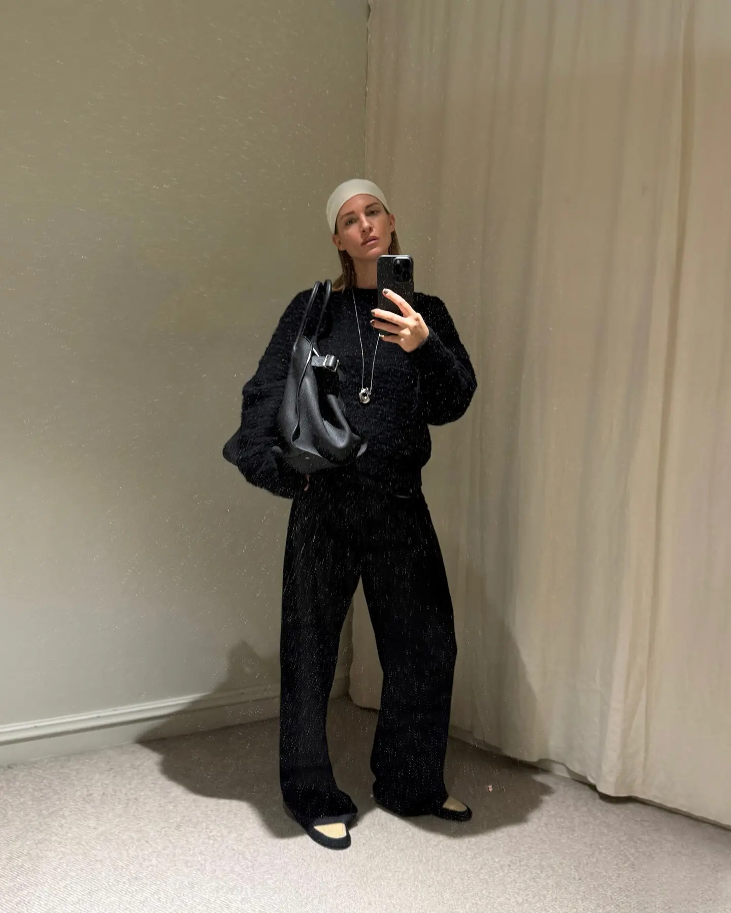 Changing Room Blurriness: Fashion Essentials Unmasked Mirjam Flatau shows chic style in a blurred changing room, merging casual trends & grace!