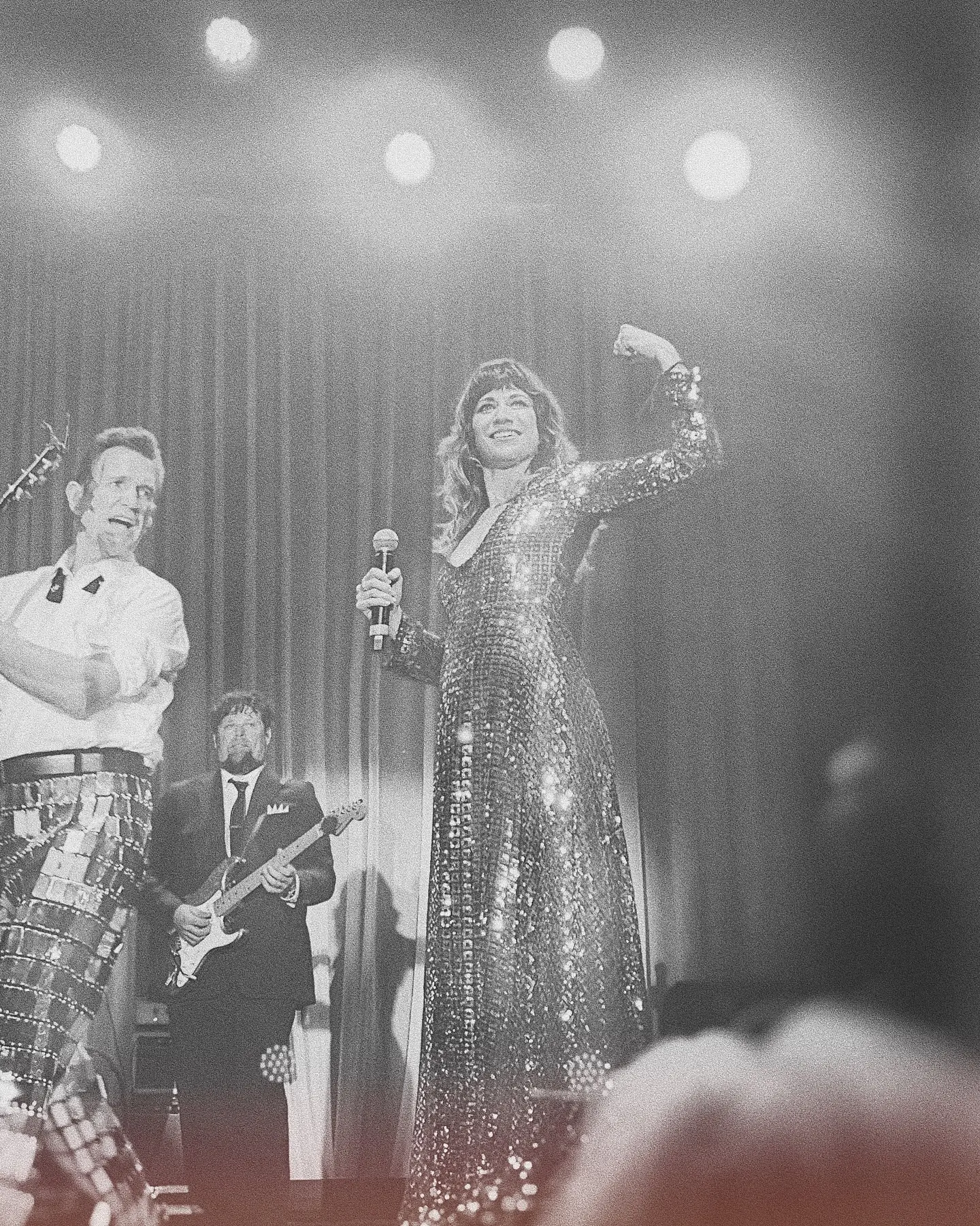 An intriguing shot captures a moment during a live show with a twist of mystery and tour energy.