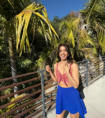 Actress channels sun-soaked energy with palm trees, vibrant hues and chic makeup artistry.